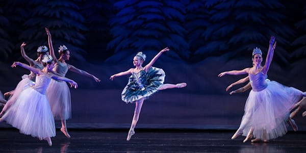 A scene from the Nutcracker ballet, showcasing dancers in elegant costumes on stage.